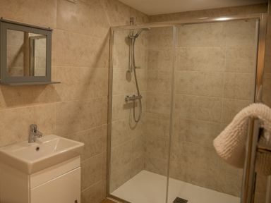 A bathroom with a sink and a wall mirror cabinet next to a walk-in shower at Bears Court Barn 5 in Little Rissington near Bourton-On-The-Water