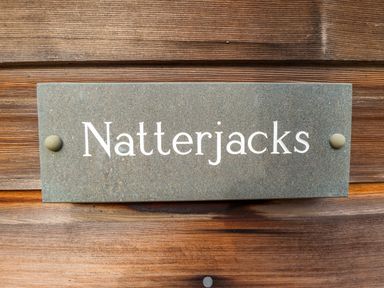 A stone nameplate with the text Natterjacks fixed on a wooden surface at Natterjacks in Syderstone