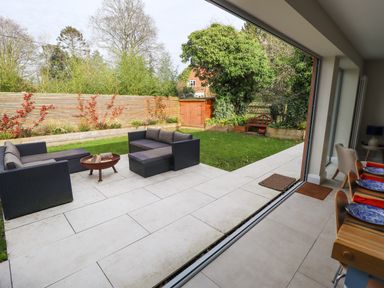 A garden patio with outdoor seating and a fire pit visible from the dining area at Natterjacks in Syderstone