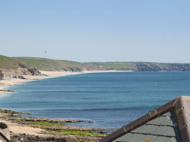A coastal landscape with sandy beaches rocky cliffs and green hills by the sea at The Loft in Porthleven