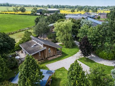 An outdoor view of houses and farm buildings at Cedrus Lodge in Skelton near Penrith