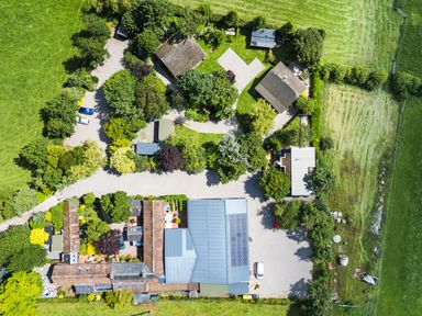 An aerial view of a property with multiple buildings and landscaping at Larch Lodge Skelton near Penrith