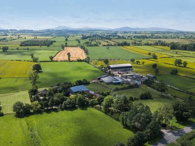 An aerial view of a farm surrounded by fields near Larch Lodge in Skelton near Penrith
