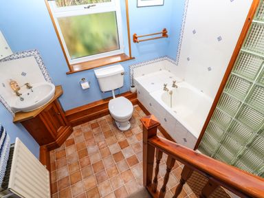 A bathroom with a bathtub sink toilet radiator and a window at Crescent Cottage in Haltwhistle near Hadrians Wall