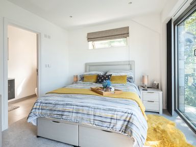 A bedroom with a bed and nightstand at Pentire in St Minver