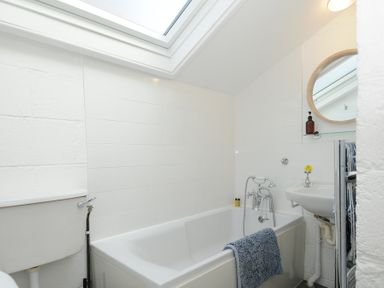 A bathroom with a bathtub toilet sink mirror and skylight at Little Ruffo in Trebarwith near Tintagel