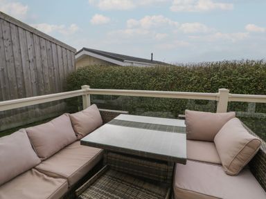 An outdoor seating area with a sofa and table at Platinum Lodge (503) Talybont