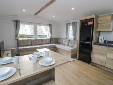 A living room with a sofa and dining table at Lido Silver Plus 111 Prestatyn