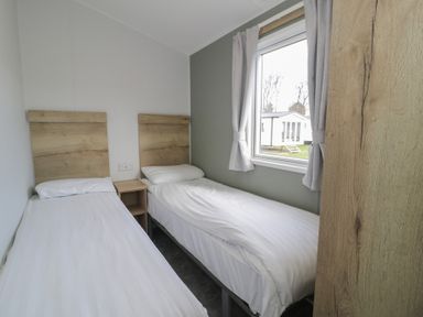 A bedroom with two single beds and a window at Lido Silver Plus 111 Prestatyn