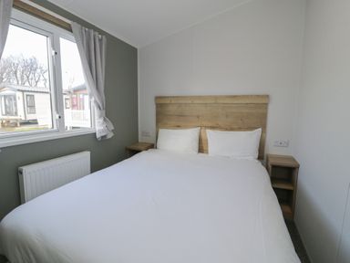 A bedroom with a bed and bedside table at Lido Silver Plus 111 Prestatyn