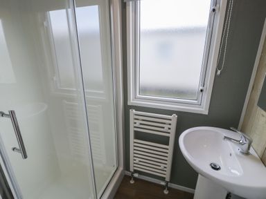 A bathroom with a shower and washbasin at Lido Silver Plus 111 Prestatyn