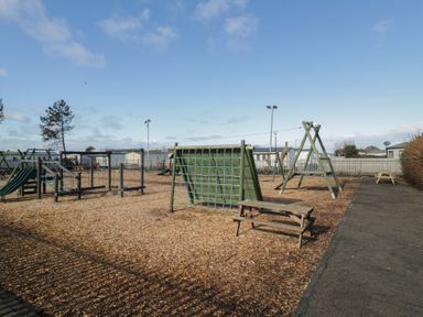 A playground with swings and a climbing frame at Lido Silver Plus 111 Prestatyn