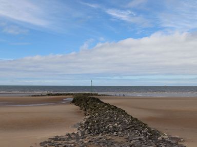 A beach with a rock formation and sea at Lido Silver Plus 111 in Prestatyn