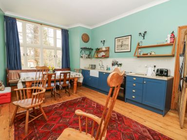 A kitchen with blue cabinets wooden furniture and a red patterned rug at Plas Pontfaen near Fishguard and Newport Pembrokeshire