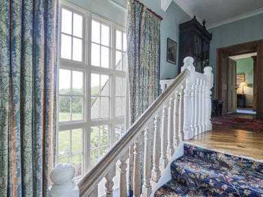 A staircase with curtains and a window at Plas Pontfaen near Fishguard and Newport, Pembrokeshire