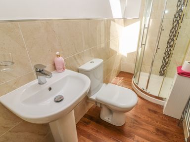 A bathroom with a sink toilet and glass shower enclosure at Woodbine Cottage in Ambleside
