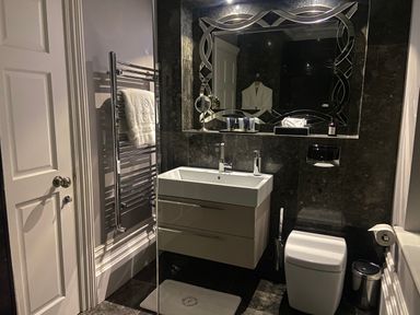 A bathroom with a sink cabinet towel rack toilet and a large mirror at Hunters Moon in Charlestown