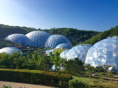 Geodesic domes surrounded by greenery and hills under a clear sky at Hunters Moon in Charlestown