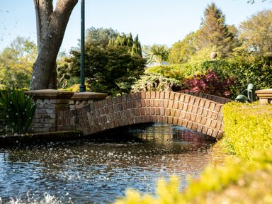 A small brick arched bridge over water with greenery and trees in the background at Hunters Moon in Charlestown