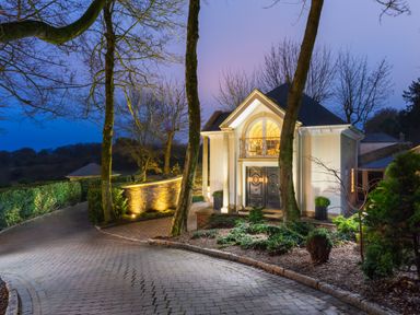 A driveway leading to a house entrance with columns and double doors at Hunters Moon in Charlestown