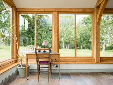 A conservatory with a desk and chair at Henhouse Farm in Bodenham