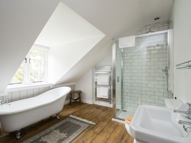 A bathroom with a bathtub and shower at Henhouse Farm in Bodenham