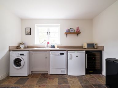 A laundry room with appliances and a window at Henhouse Farm in Bodenham