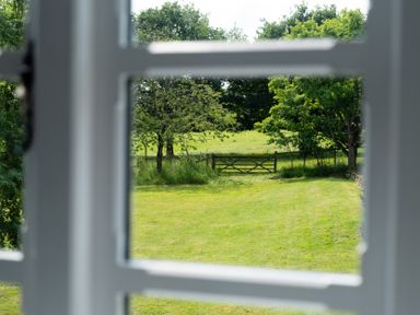 An outdoor view showing trees and a gate from a window at Henhouse Farm Bodenham