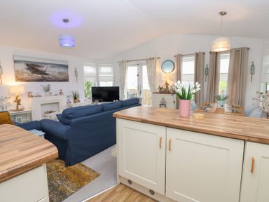 A living room with a sofa, television and dining table at The Sanctuary near Badgers Retreat Holiday Park near Catterick Garrison, North Yorkshire