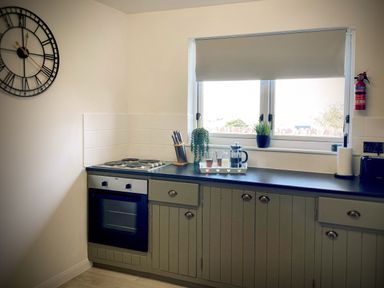 A kitchen with an oven stove countertop window knife block and plants at Penkenna in Crackington Haven