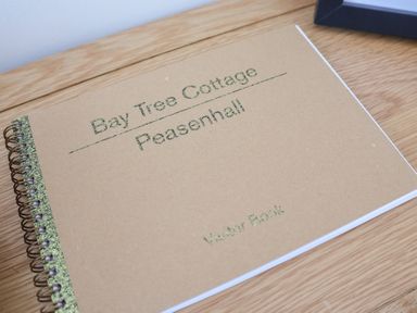 A visitor book on a wooden surface at Bay Tree Cottage in Peasenhall