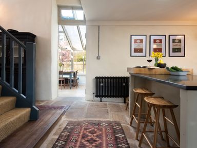 A kitchen with bar stools and a dining area at The Old Coach House Eglingham near Alnwick