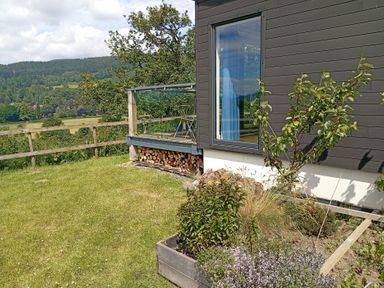A garden view with a deck and plants at Dundarach in Aberfeldy