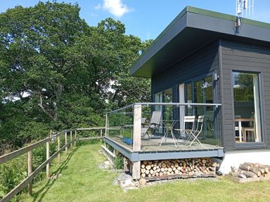 A deck with chairs and a table at Dundarach Aberfeldy