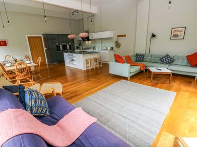 A living room with a sofa and dining area at The Old Creamery in Ffairfach