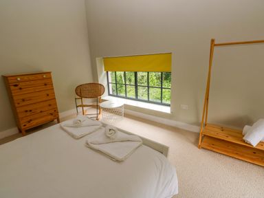 A bedroom with a bed and wooden furniture at The Old Creamery in Ffairfach