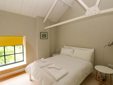 A bedroom with a bed and a window at The Old Creamery in Ffairfach