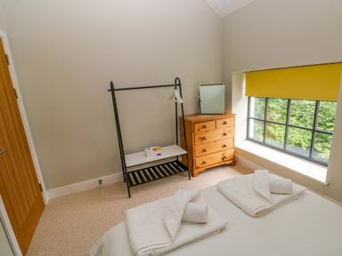 A bedroom with a bed and dresser at The Old Creamery in Ffairfach