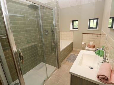 A bathroom featuring a shower, bathtub, sink, and toilet at The Old Creamery in Ffairfach