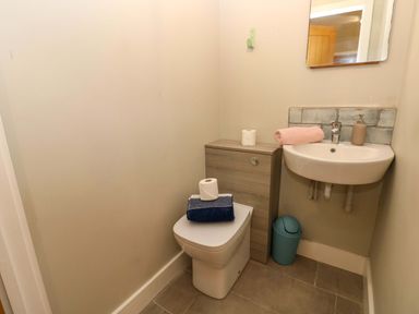 A bathroom with a sink, toilet, and small cabinet at The Old Creamery in Ffairfach