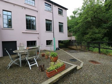 An outdoor patio with a table and chairs at The Old Creamery in Ffairfach