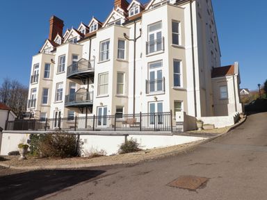An exterior view of a multi-story residential building with balconies and windows at Apartment 7 Mansion House Tenby