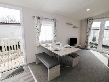 A dining area with a table and chairs at Gold Caravan (316) Talybont