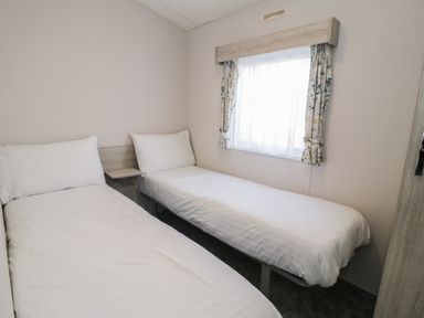 A bedroom with two beds and a window at Gold Caravan (316) Talybont