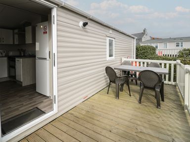 An outdoor deck with a table and chairs at Gold Caravan (316) Talybont