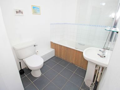 A bathroom with a toilet bathtub and sink at Y Beudy The Old Byre in Llanbedr