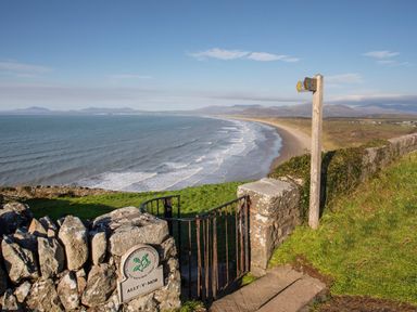 A beach view with a path and signpost at Alet-y-Mor in Talybont