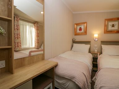 A bedroom with two single beds and a wooden dressing table at Lily Rose Lodge White Cross Bay near Troutbeck Bridge