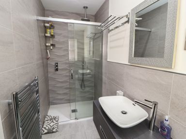A bathroom with a shower enclosure a sink with a faucet and a mirror at 4 Centurion Rise in Penrith