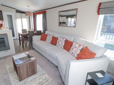 A living room with a large sofa and dining table in the background at Downtime Lodge near Felton